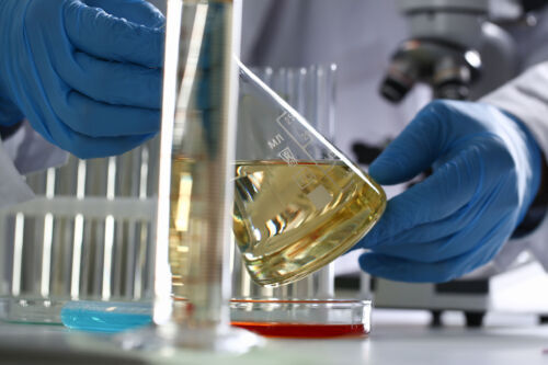 Male,Hand,Hold,Yellow,Liquid,In,Test,Tube.,Conveyor,Line Male hand hold yellow liquid in test tube